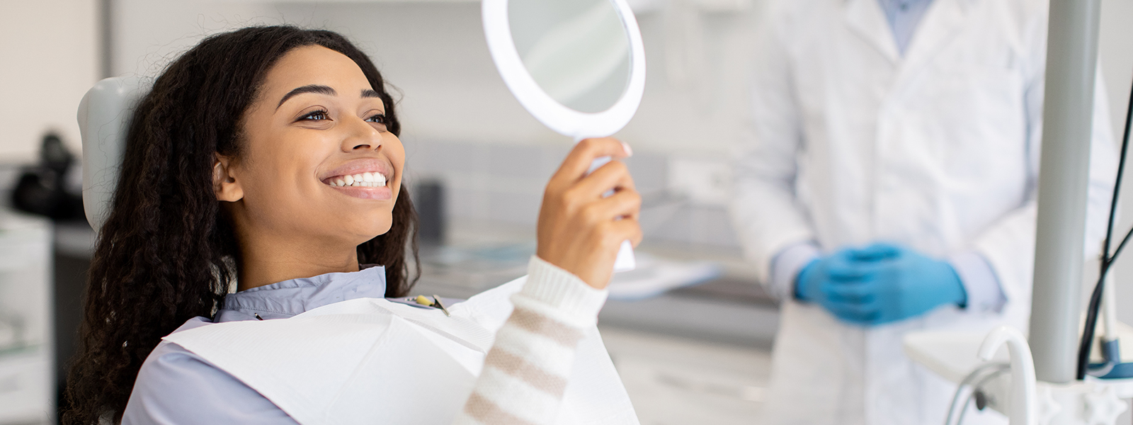 A happy patient in a dental chair - after having a dental cleaning service.